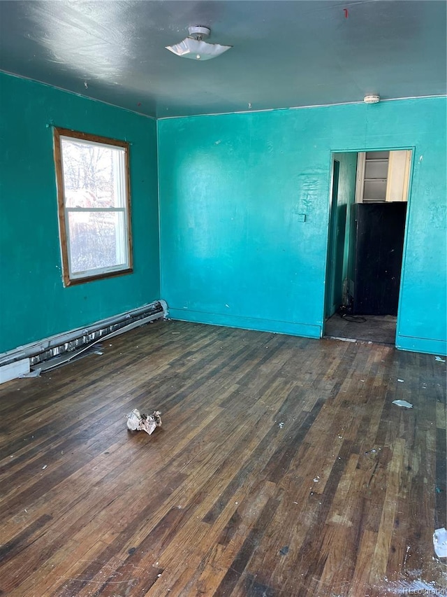 unfurnished room featuring a baseboard radiator and dark wood-type flooring