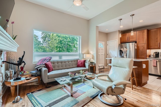 living room featuring ceiling fan and light hardwood / wood-style floors