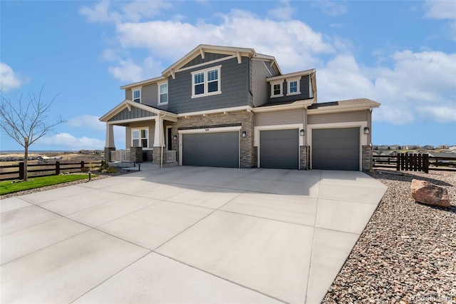 craftsman-style house featuring a porch, fence, stone siding, and concrete driveway