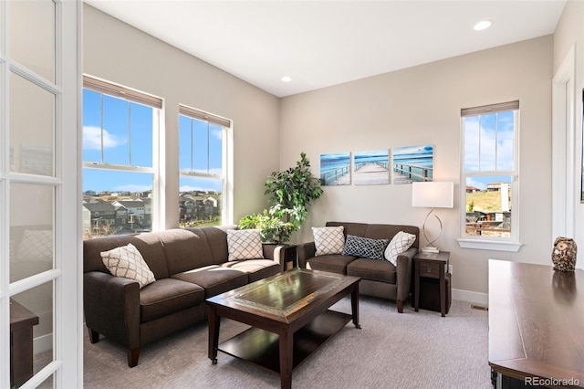 living room with light colored carpet, recessed lighting, and baseboards