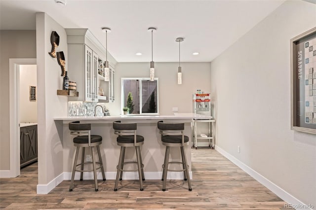 kitchen with light countertops, a kitchen breakfast bar, and a peninsula