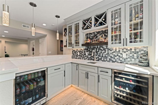 bar featuring beverage cooler, a sink, wet bar, and visible vents