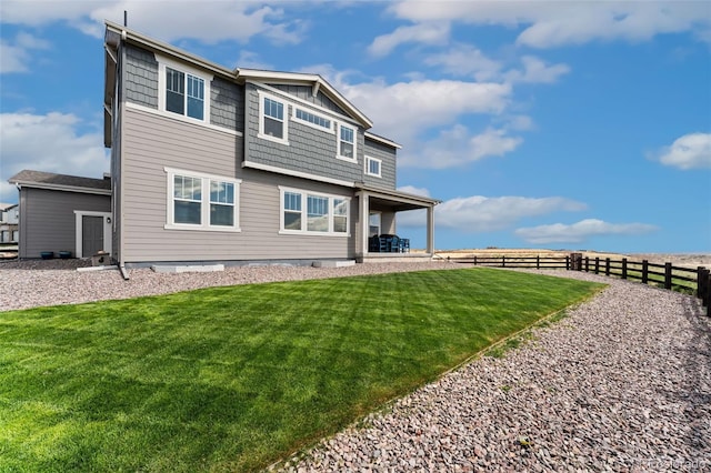 back of house with a lawn and fence