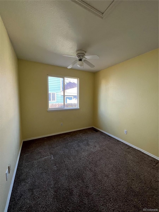 spare room with ceiling fan and dark carpet