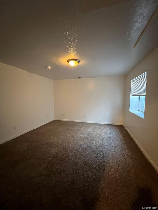 carpeted spare room featuring a textured ceiling