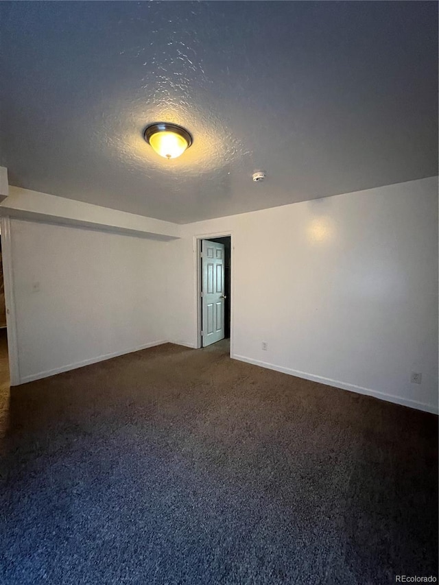 carpeted empty room featuring a textured ceiling