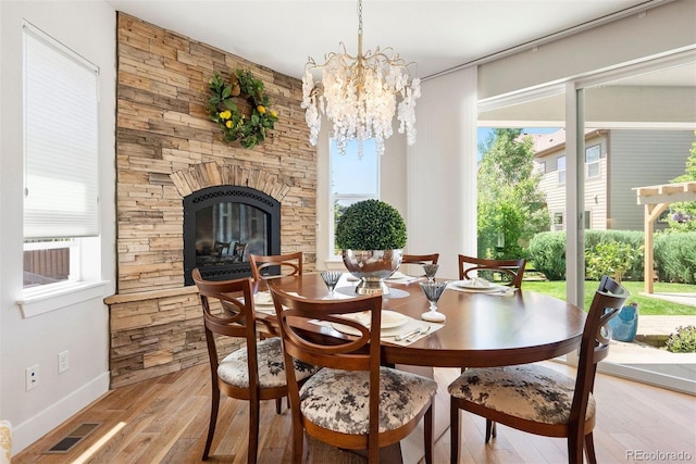 4142 Saltbrush Ct, Loveland, CO 80538 - dining area with light wood-style floors, a chandelier, and a fireplace