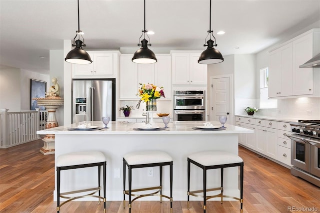 4142 Saltbrush Ct, Loveland, CO 80538 - kitchen with high quality appliances, a breakfast bar area, light countertops, tasteful backsplash, and a center island
