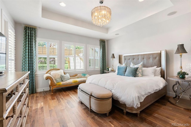 4142 Saltbrush Ct, Loveland, CO 80538 - bedroom with a tray ceiling, hardwood / wood-style floors, a chandelier, and recessed lighting