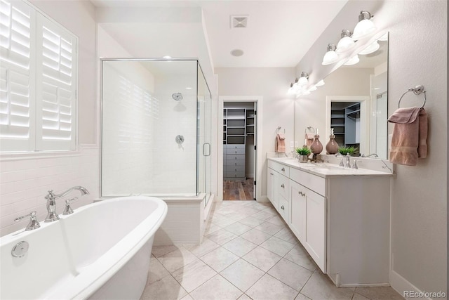 4142 Saltbrush Ct, Loveland, CO 80538 - bathroom with a soaking tub, a stall shower, vanity, a walk in closet, and tile patterned floors