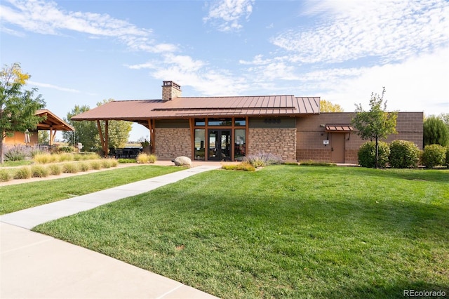 4142 Saltbrush Ct, Loveland, CO 80538 - view of front of home with a standing seam roof, a chimney, french doors, a front yard, and stone siding