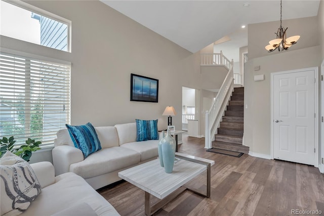 9884 Sydney Ln, Highlands Ranch, CO 80130 - living room with high vaulted ceiling, a chandelier, stairs, wood finished floors, and baseboards