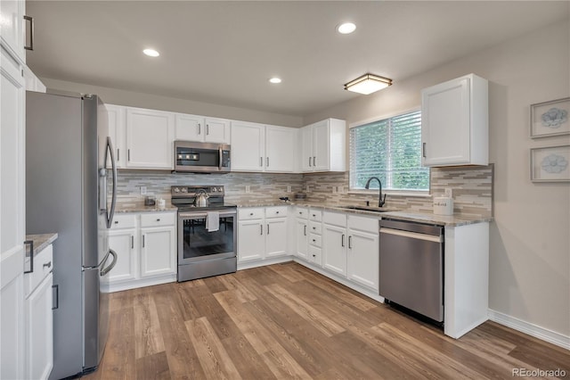 9884 Sydney Ln, Highlands Ranch, CO 80130 - kitchen with stainless steel appliances, a sink, decorative backsplash, white cabinetry, and recessed lighting