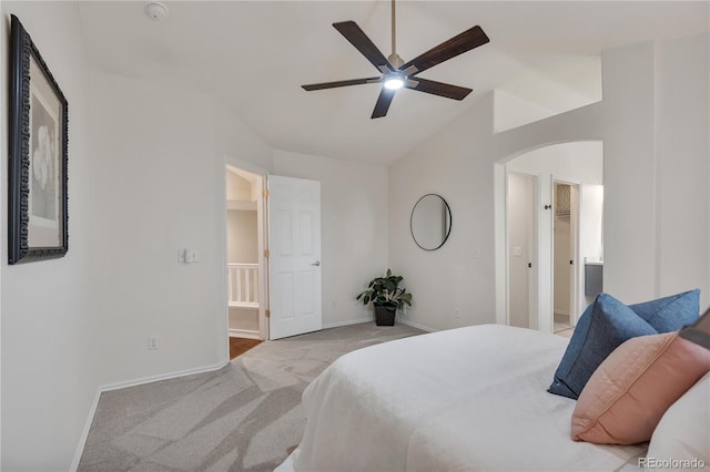 9884 Sydney Ln, Highlands Ranch, CO 80130 - carpeted bedroom featuring arched walkways, baseboards, lofted ceiling, connected bathroom, and ceiling fan