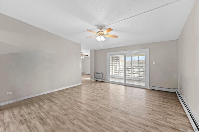 unfurnished room featuring light wood-type flooring, a textured ceiling, a wall mounted AC, baseboard heating, and ceiling fan