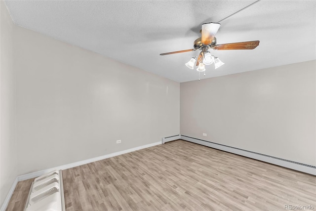 empty room featuring a baseboard radiator, a textured ceiling, and light wood-type flooring