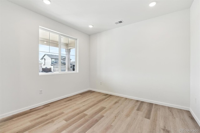 spare room with visible vents, recessed lighting, baseboards, and wood finished floors