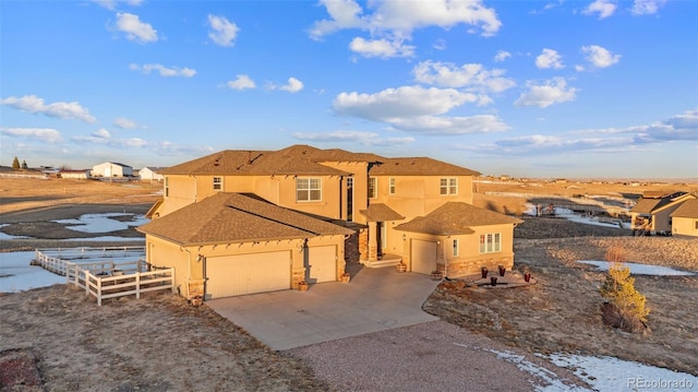 view of front of property with fence, stucco siding, a garage, stone siding, and driveway