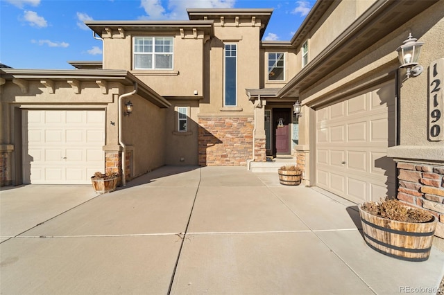 view of front of home with stucco siding, stone siding, a garage, and concrete driveway