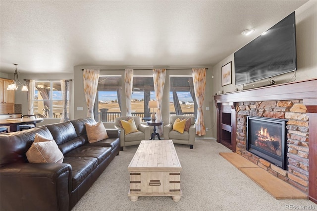 living room featuring a notable chandelier, a stone fireplace, light colored carpet, and a textured ceiling