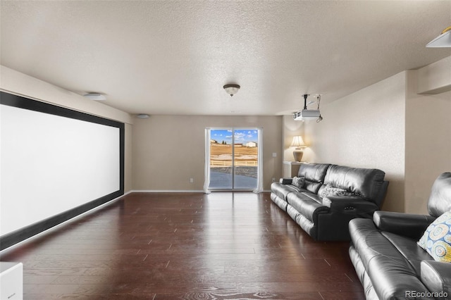 cinema with a textured ceiling, baseboards, and hardwood / wood-style flooring