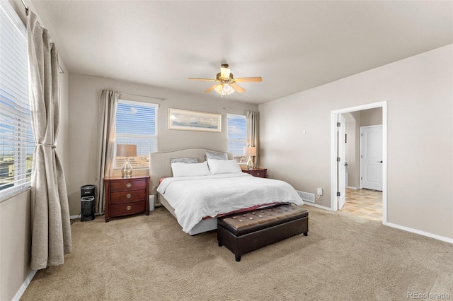 carpeted bedroom featuring visible vents, multiple windows, baseboards, and ceiling fan