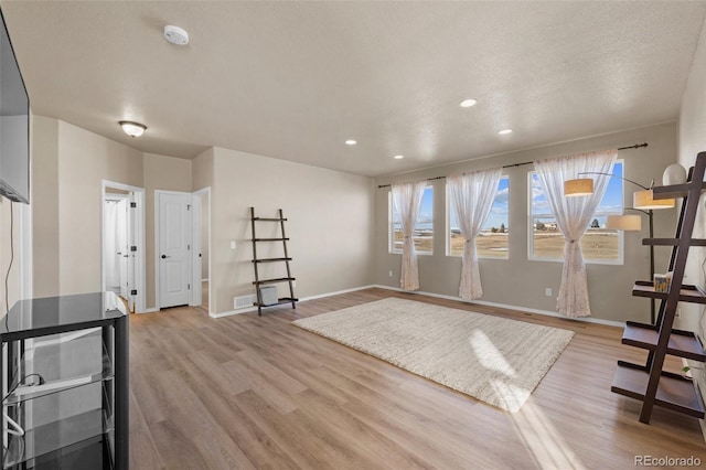 workout room featuring plenty of natural light, baseboards, and light wood-type flooring