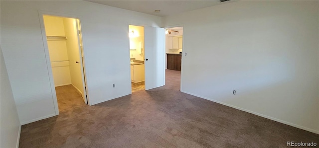 2355 E Geddes Ave Unit G24, Centennial, CO 80122 - unfurnished bedroom featuring a walk in closet, carpet floors, and a closet