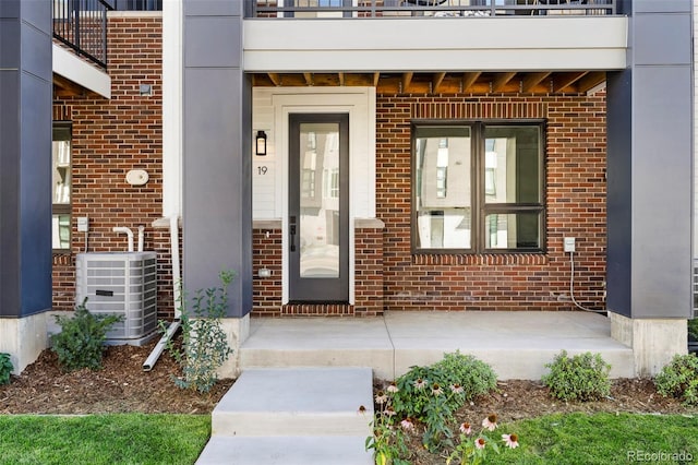 property entrance with a patio area and central AC unit