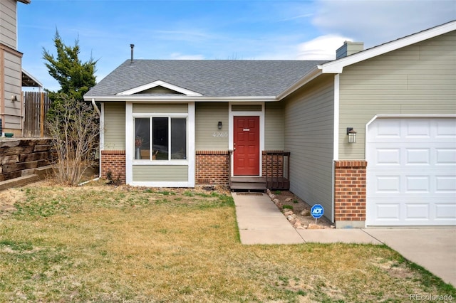 view of front facade with a shingled roof, a front yard, a garage, and brick siding