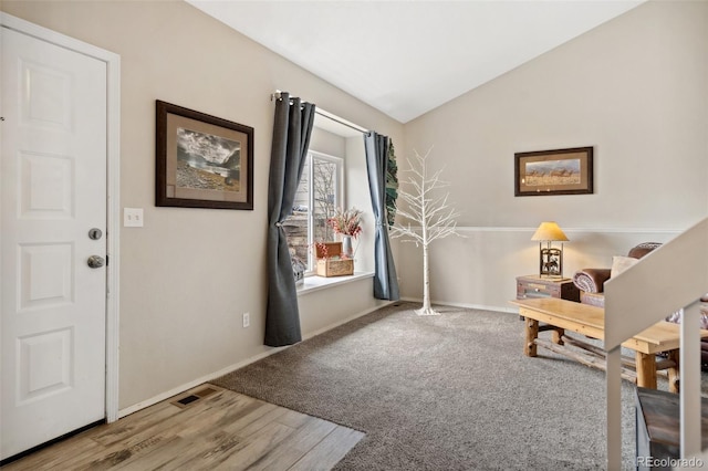 sitting room featuring baseboards, vaulted ceiling, visible vents, and carpet flooring