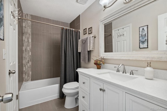 full bathroom featuring shower / bath combo with shower curtain, toilet, vanity, and a textured ceiling