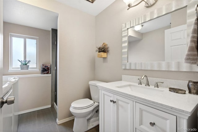 full bath featuring a shower with door, baseboards, toilet, and vanity