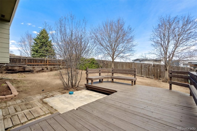 wooden deck with a fenced backyard
