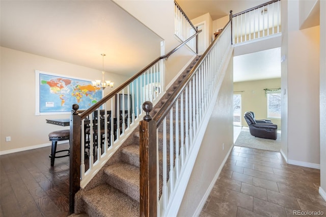 staircase featuring hardwood / wood-style floors and an inviting chandelier