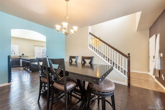 dining space with a notable chandelier, dark hardwood / wood-style flooring, and sink