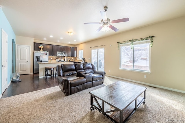 carpeted living room with ceiling fan