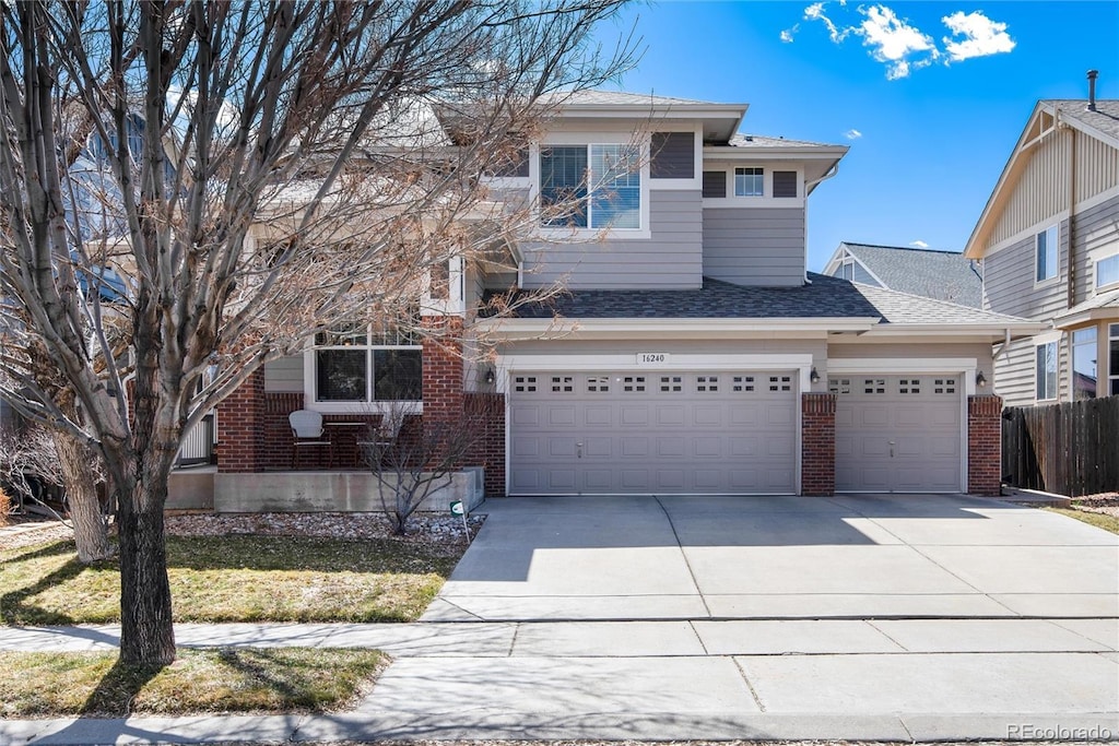 16240 E 119th Ave, Commerce City, CO 80022 - view of front of house with concrete driveway, a garage, fence, and brick siding