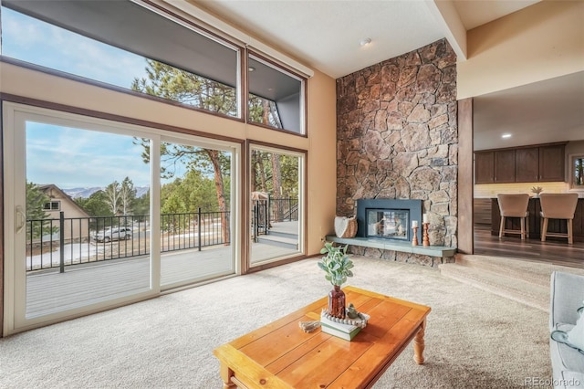 carpeted living room with a towering ceiling, a fireplace, and a wealth of natural light