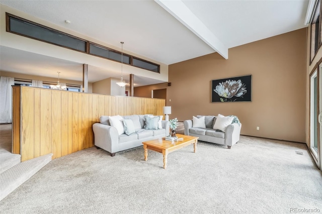 carpeted living room featuring beam ceiling