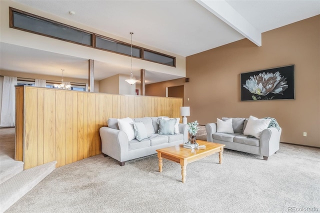 living room featuring carpet flooring, beam ceiling, and a notable chandelier