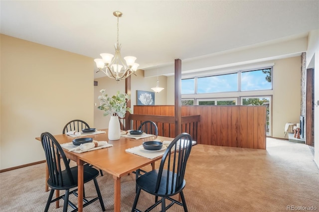 dining area with light carpet and a notable chandelier