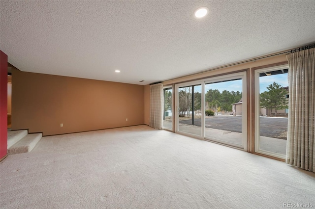 unfurnished room with light carpet and a textured ceiling