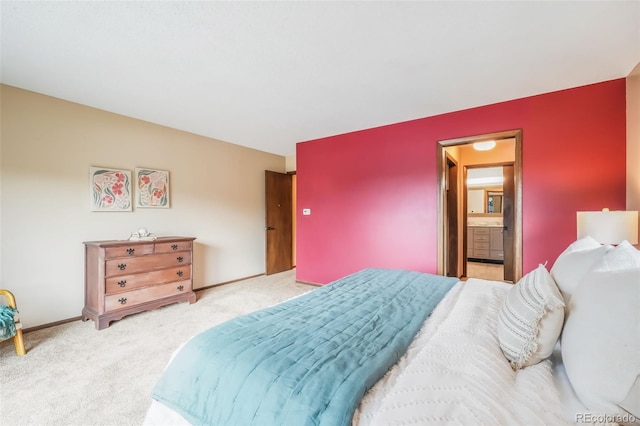 bedroom featuring light colored carpet and ensuite bathroom