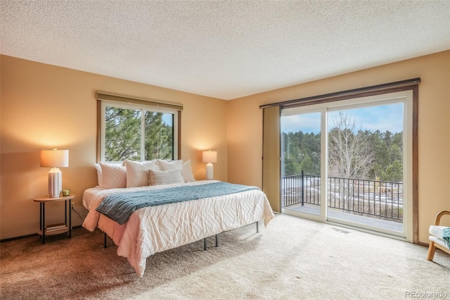 carpeted bedroom with access to exterior and a textured ceiling