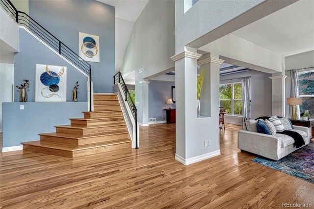 581 Stonemont Dr, Castle Pines, CO 80108 - stairway featuring wood finished floors, baseboards, a high ceiling, and ornate columns