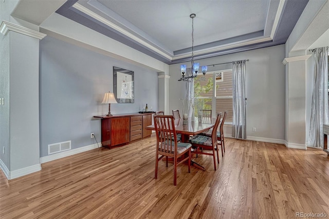 581 Stonemont Dr, Castle Pines, CO 80108 - dining space with a tray ceiling, a chandelier, light wood-style floors, baseboards, and crown molding