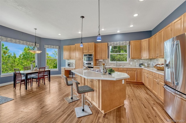 581 Stonemont Dr, Castle Pines, CO 80108 - kitchen with appliances with stainless steel finishes, light countertops, light wood-type flooring, healthy amount of natural light, and recessed lighting