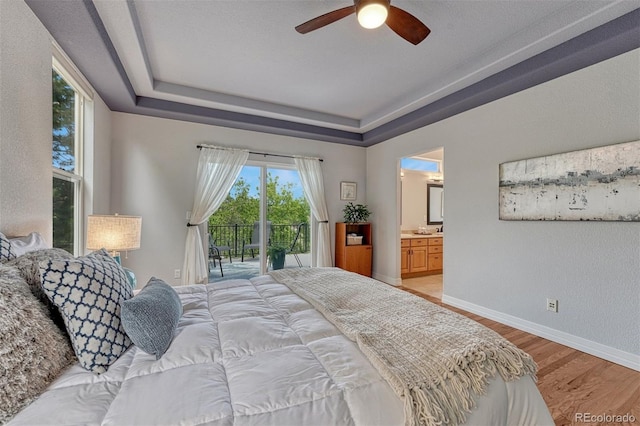 581 Stonemont Dr, Castle Pines, CO 80108 - bedroom featuring access to exterior, light wood-style floors, a raised ceiling, baseboards, and ensuite bath