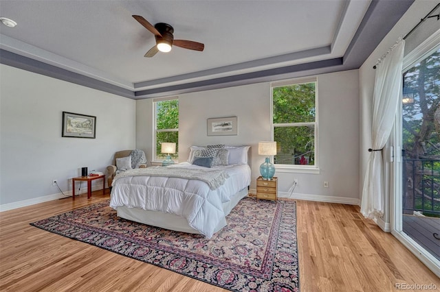581 Stonemont Dr, Castle Pines, CO 80108 - bedroom with a raised ceiling, light wood-style flooring, baseboards, and access to exterior